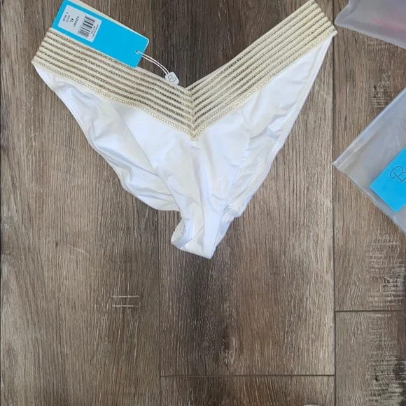NWT Beach Bunny White and Gold Bikini 2 piece set
Halter top (L)
Bottoms (XL) - Picture 2 of 9